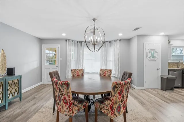 a kitchen with stainless steel appliances granite countertop a refrigerator a sink dishwasher and white cabinets with wooden floor