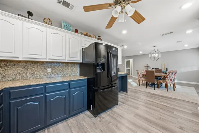 a kitchen with granite countertop a sink a counter space appliances and cabinets