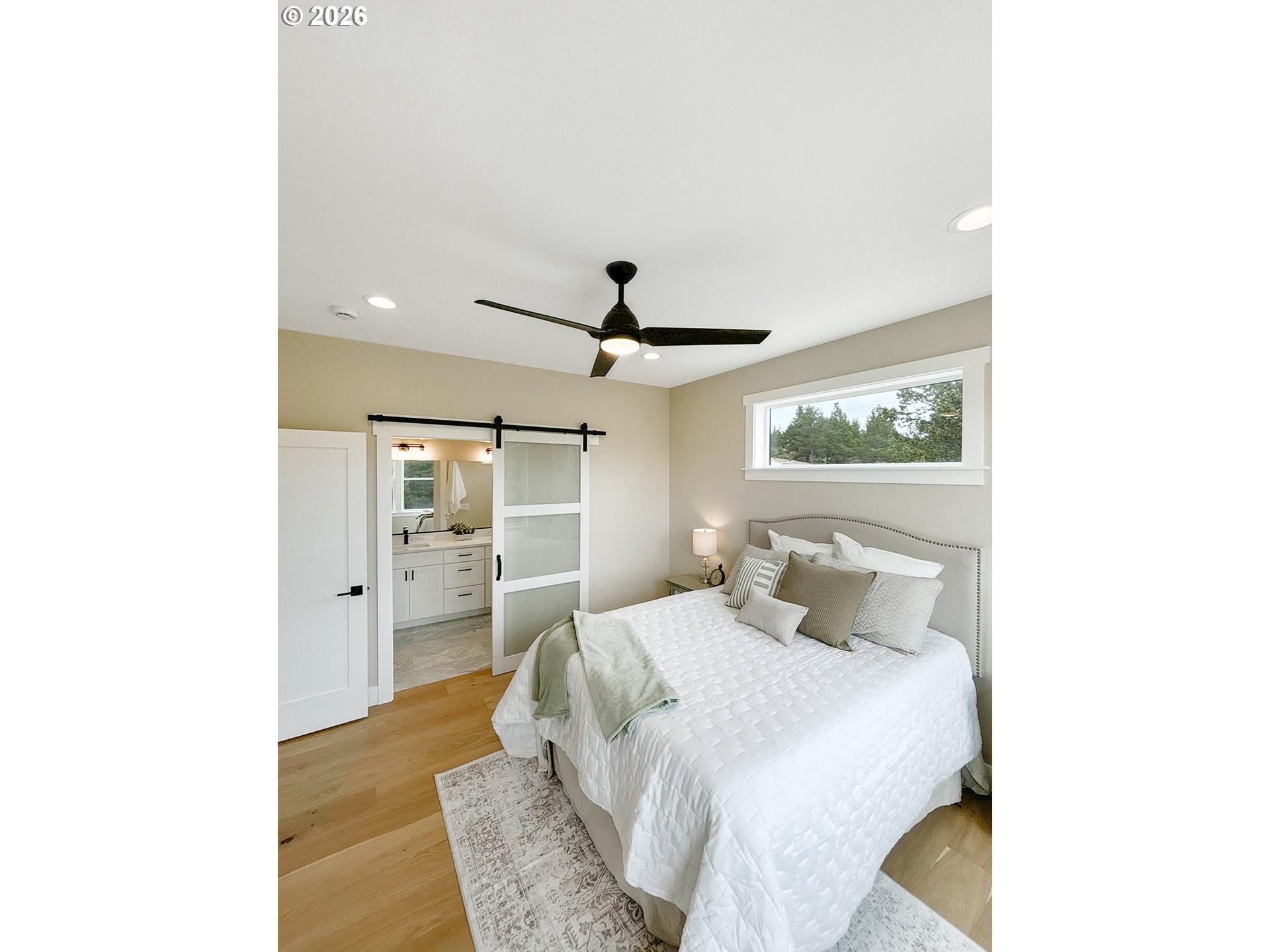 466 Meadows Drive Nehalem, OR 97131 - Photo 13 of 28 a bedroom with a large bed and a chandelier