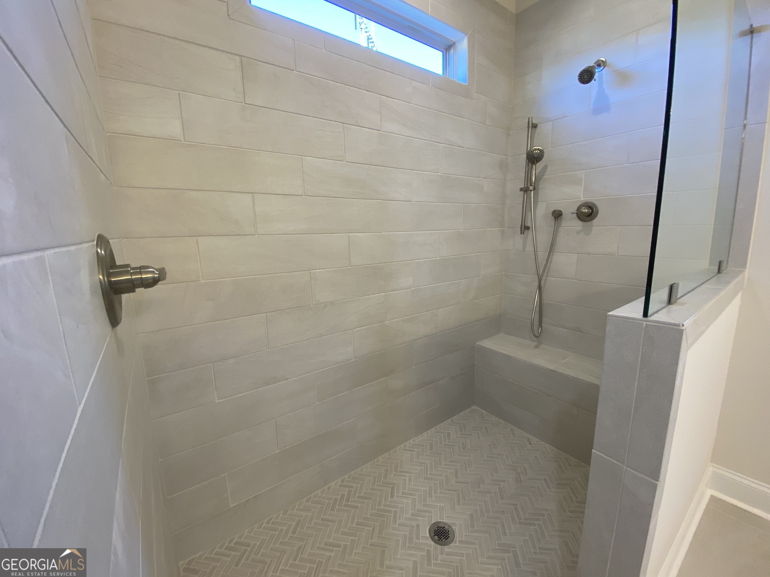 174 Oakdale Road, Unit 34 Jefferson, GA 30549 - Photo 36 of 64 Super shower has a bench, hand held, shampoo niche, and transom window