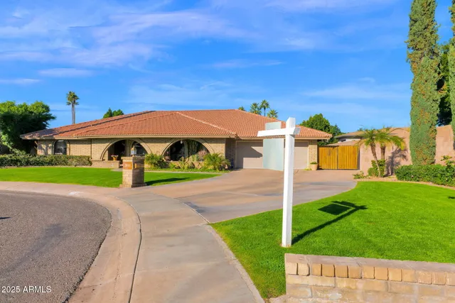 a view of a street with a building and a small yard