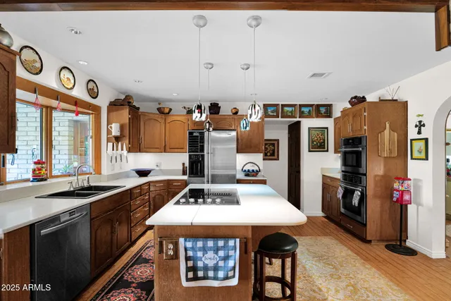 a kitchen with stainless steel appliances a stove a sink and a refrigerator
