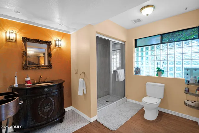 a bathroom with a sink a toilet and shower