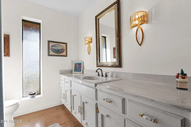 a en suite bathroom with a granite countertop sink and a mirror
