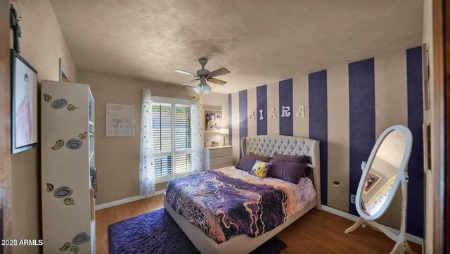 a bedroom with a bed lamps and a large mirror on the dresser
