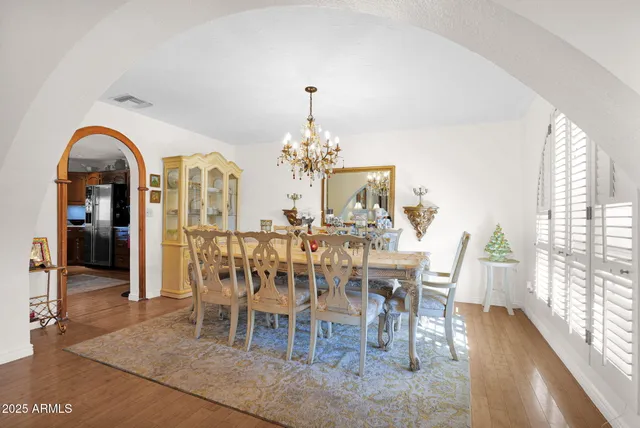 a dining room with furniture a chandelier and wooden floor
