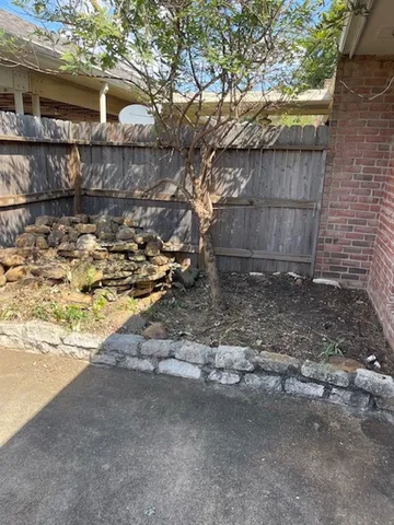 a view of a yard with wooden fence
