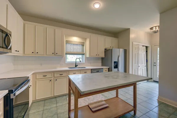 a kitchen with a sink a microwave and refrigerator