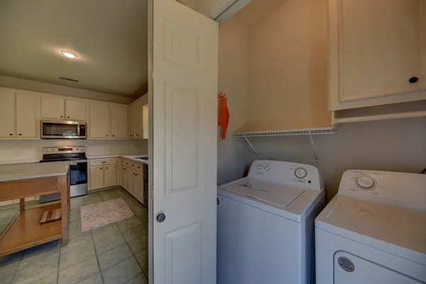 a view of washer and dryer with kitchen in the background