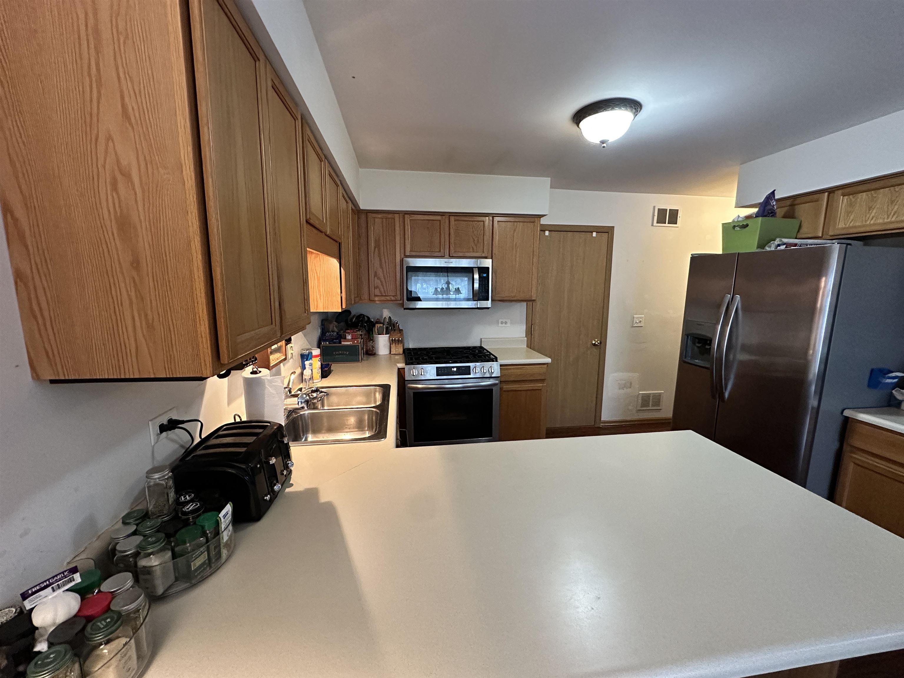 47 D Rolling Oaks Road Sugar Grove, IL 60554 - Photo 9 of 23 a kitchen with granite countertop a refrigerator a stove a sink dishwasher and wooden cabinets