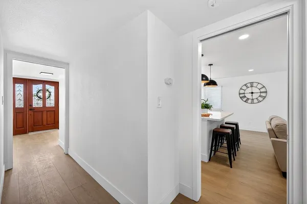 a view of a hallway to a livingroom with furniture and wooden floor