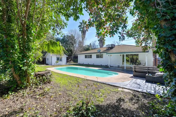 a view of a house with backyard and sitting area