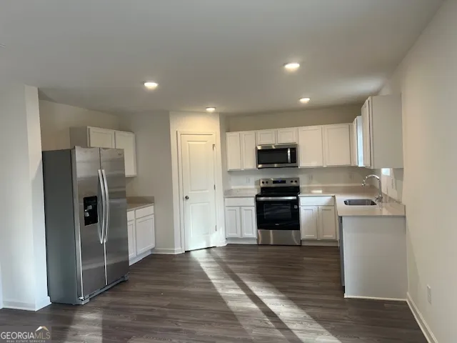 a kitchen with a refrigerator and a stove top oven