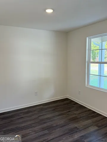 a view of a room that has wooden floor and large window