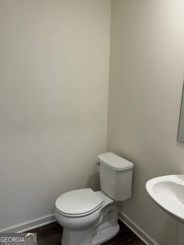 a white toilet sitting next to a white wall