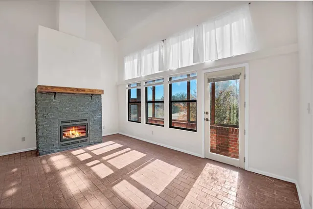 a view of an empty room with window and fire place