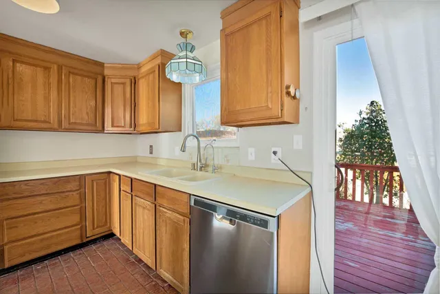 a kitchen with a sink a window and wooden floor