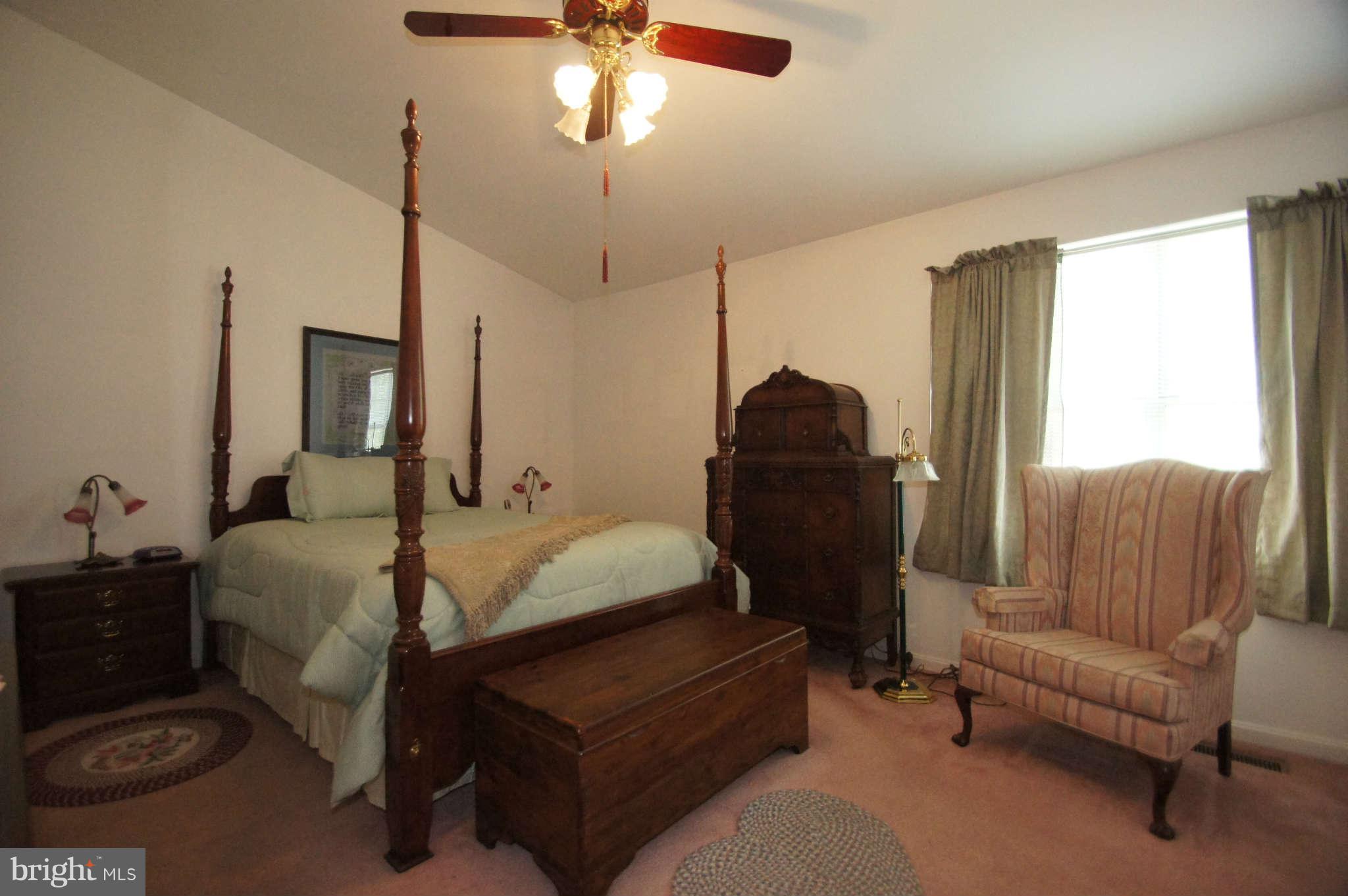 4310 Spring Avenue Baltimore, MD 21227 - Photo 14 of 30 a bedroom with a bed a couch and a chandelier