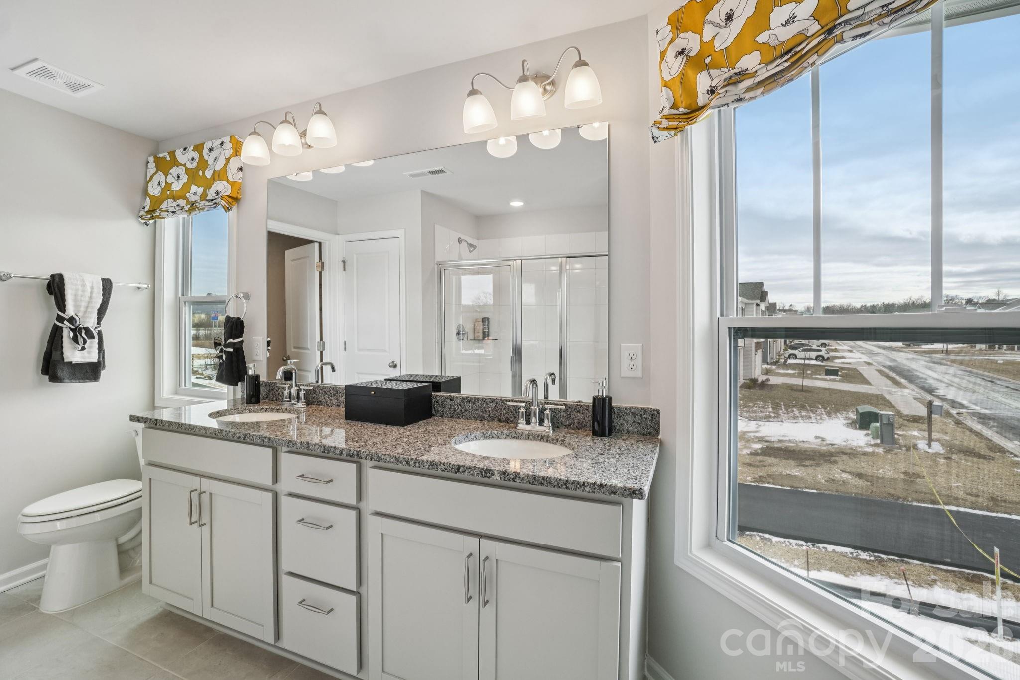 362 Lagoon Road Fletcher, NC 28732 - Photo 21 of 34 a bathroom with a granite countertop sink a large mirror and a shower
