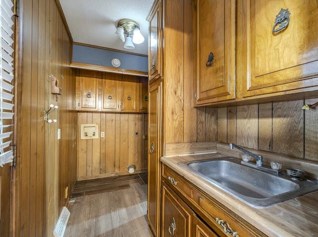 660 Hinton Road Counce, TN 38326 - Photo 23 of 40 Wood paneling throughout, built-in cabinetry, stainless steel sink, and wood-finish flooring