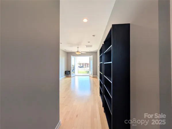 a view of a hallway with wooden floor and staircase