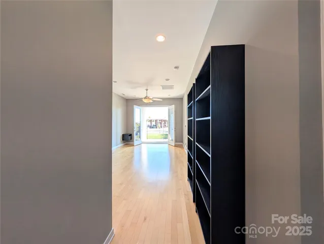 a view of a hallway with wooden floor and staircase