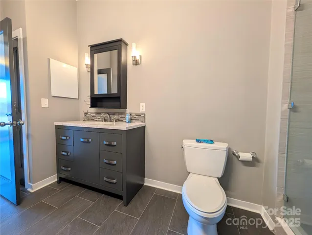 a bathroom with a toilet a sink and mirror