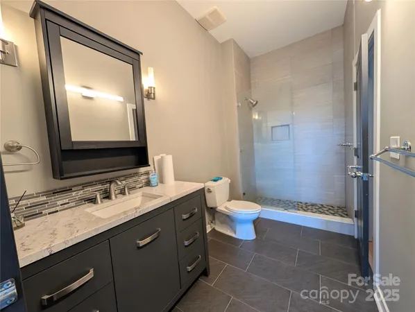 a bathroom with a granite countertop sink toilet and shower