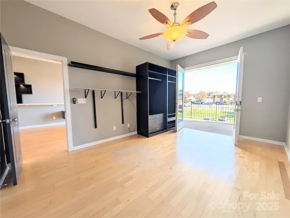 a view of an empty room with window and a kitchen view