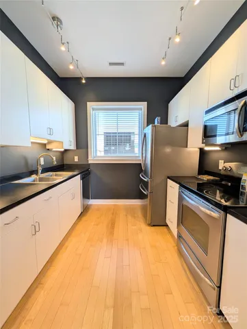 a kitchen with stainless steel appliances a refrigerator sink and microwave