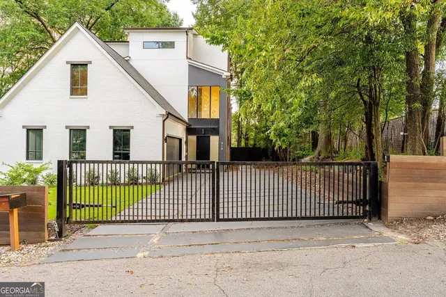 a view of a white house with a small yard and plants