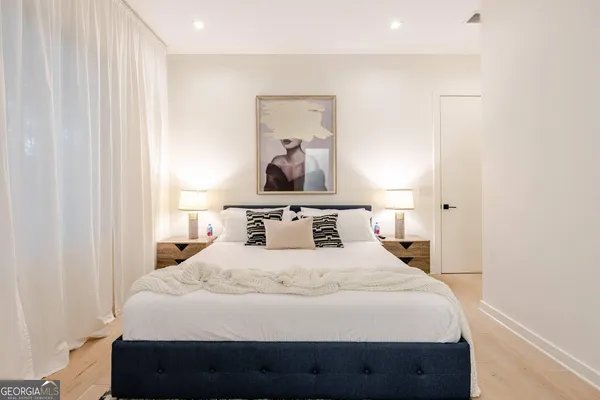 a bedroom with a bed and painting on the wall