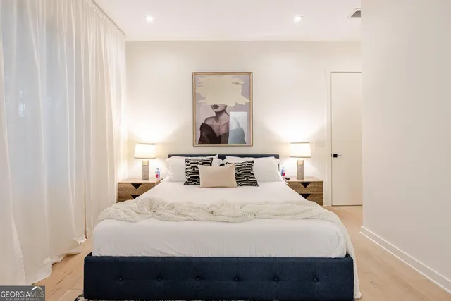 a bedroom with a bed and painting on the wall