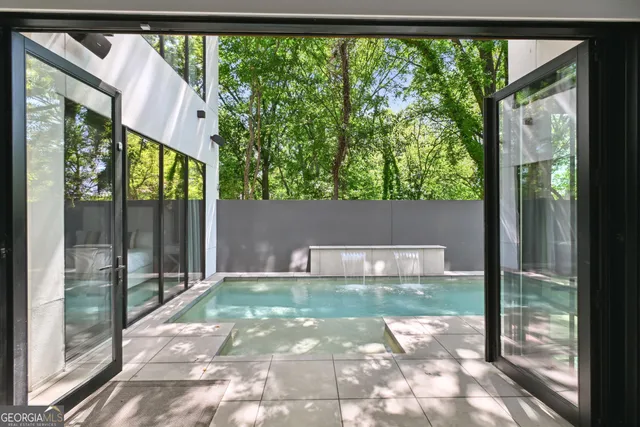 a backyard of a house with lots of green space and glass windows