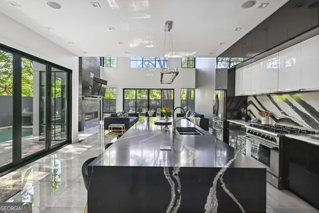 a kitchen with stainless steel appliances granite countertop a table chairs in it and wooden floors