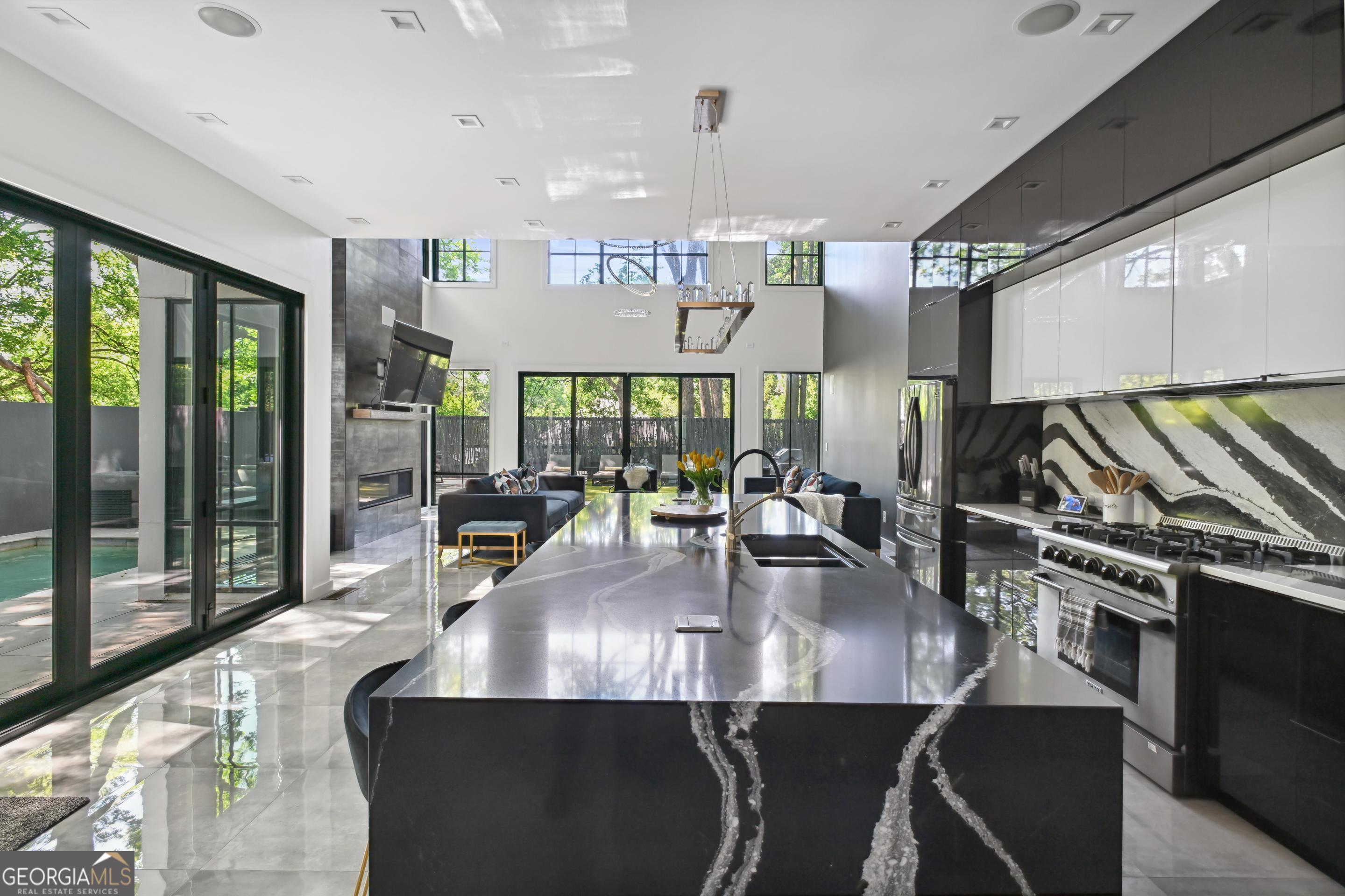 818 Verner Street Northwest Atlanta, GA 30318 - Photo 16 of 47 a kitchen with stainless steel appliances granite countertop a table chairs in it and wooden floors