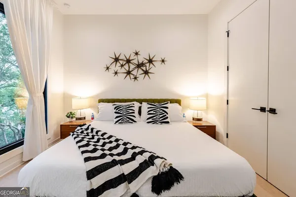 a bedroom with a large bed and a chandelier