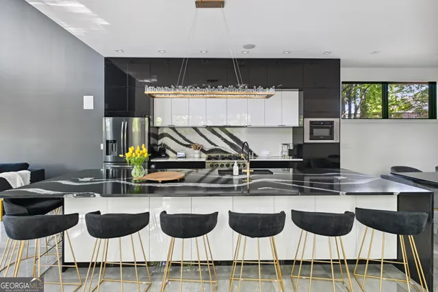 a kitchen with a dining table chairs and white wooden cabinets