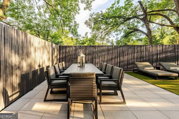a view of a chairs and tables in the back yard of a house