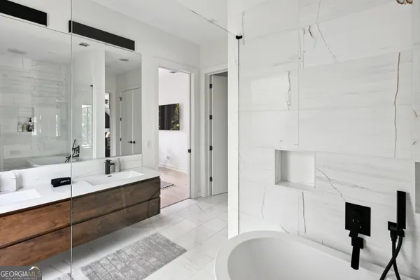 a bathroom with a tub sink shower and mirror