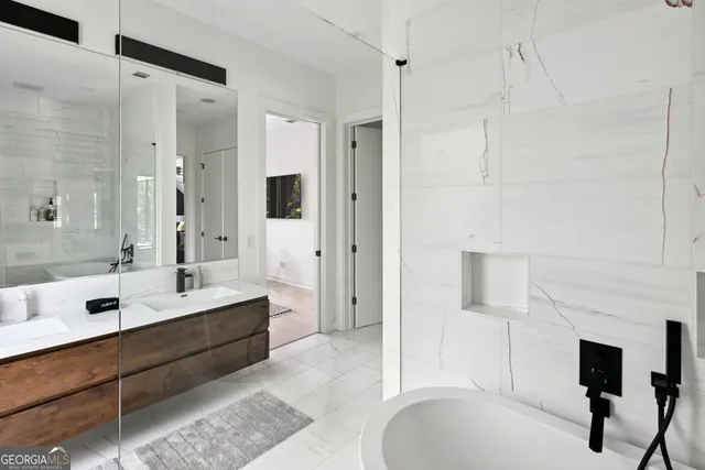 a bathroom with a tub sink shower and mirror