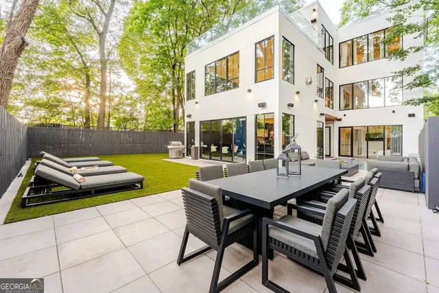a view of a patio with table and chairs and potted plants with wooden fence