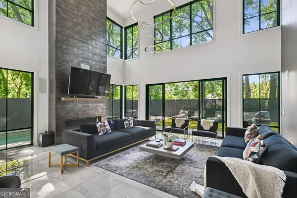 a living room with furniture fireplace and large windows