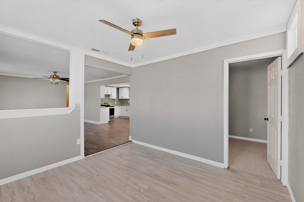 104 Maxwell Road Hackberry, TX 75036 - Photo 12 of 32 an empty room with wooden floor and a ceiling fan