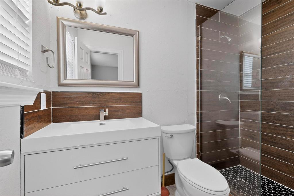 104 Maxwell Road Hackberry, TX 75036 - Photo 20 of 32 a bathroom with a sink a toilet and mirror