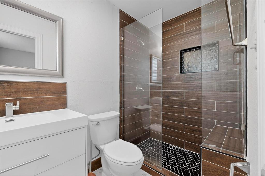 104 Maxwell Road Hackberry, TX 75036 - Photo 21 of 32 a bathroom with a toilet a sink and a shower