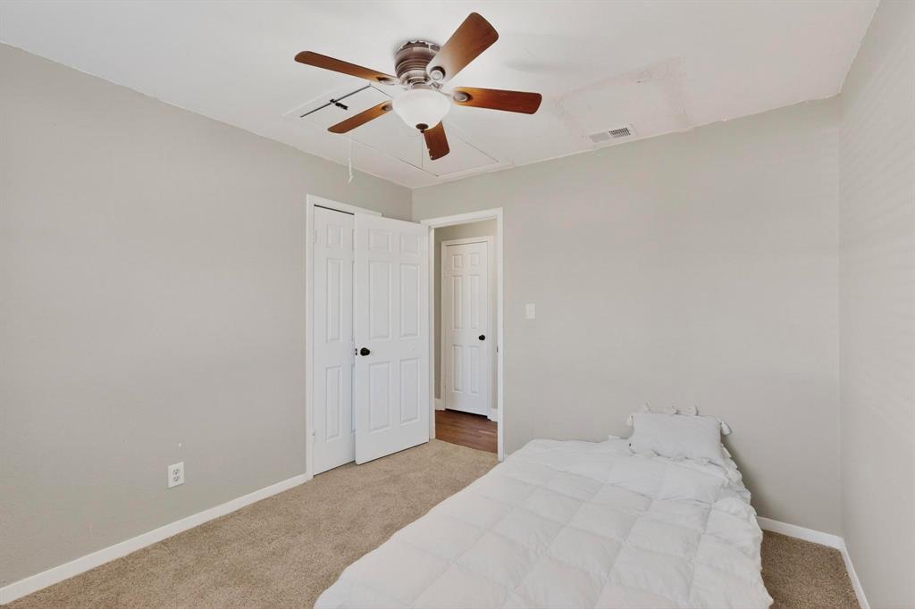 104 Maxwell Road Hackberry, TX 75036 - Photo 23 of 32 a bedroom with a large bed and a chandelier