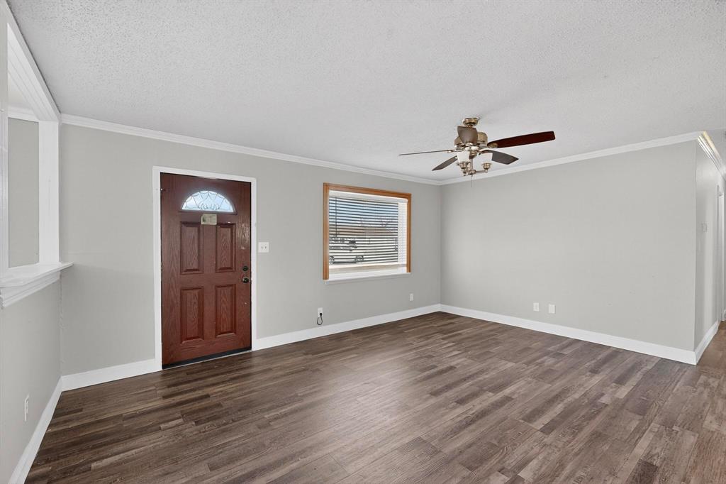 104 Maxwell Road Hackberry, TX 75036 - Photo 3 of 32 a view of an empty room with wooden floor and a window