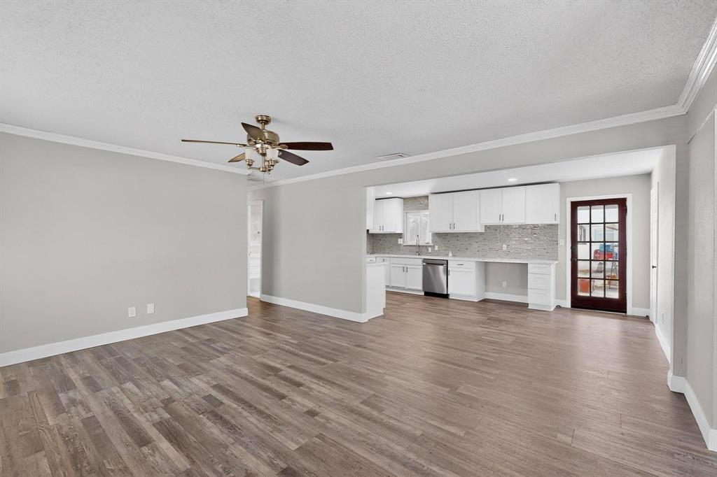 104 Maxwell Road Hackberry, TX 75036 - Photo 5 of 32 a view of a kitchen with wooden floor and a ceiling fan
