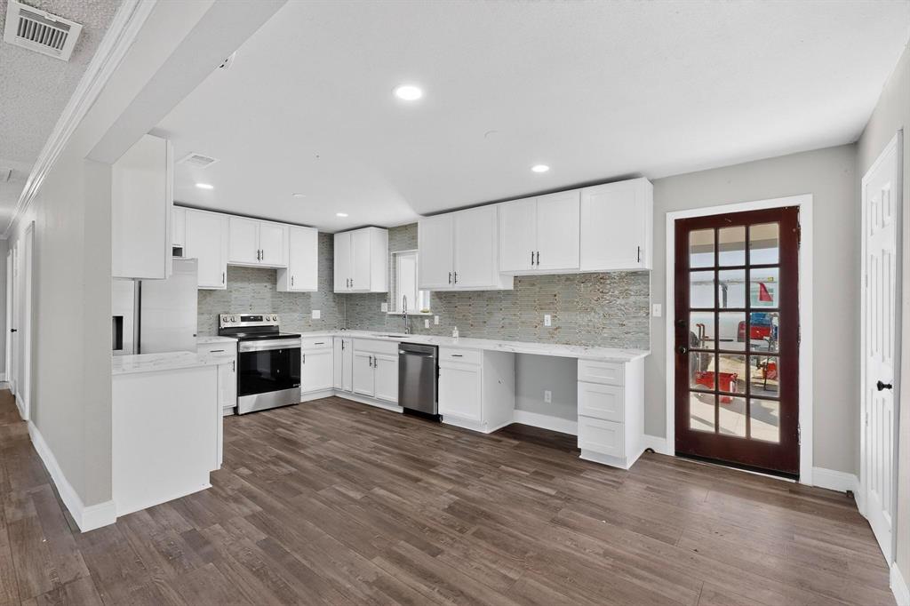 104 Maxwell Road Hackberry, TX 75036 - Photo 6 of 32 a large kitchen with cabinets wooden floor and stainless steel appliances
